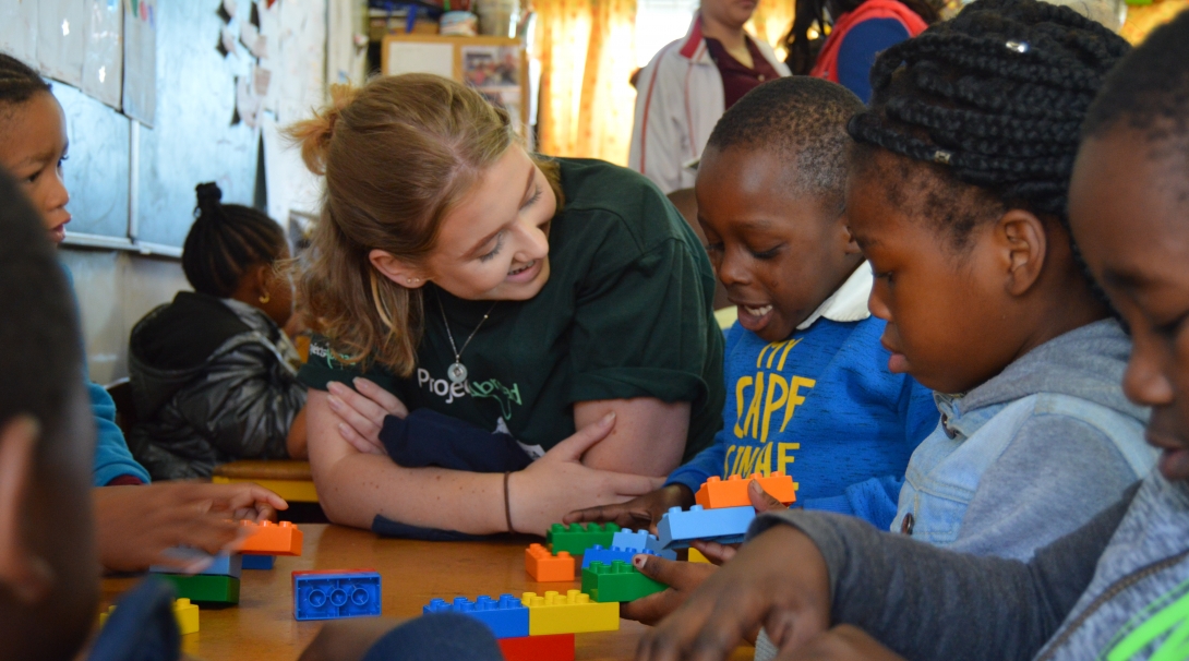 Team Trip volunteer in South Africa sits with a child Volunteer in South Africa sits with children during a lesson